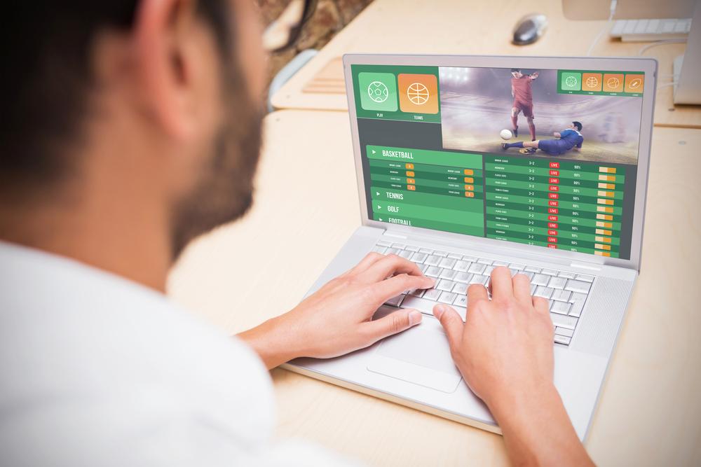 Mann nutzt ein Sportwettenangebot am Computer